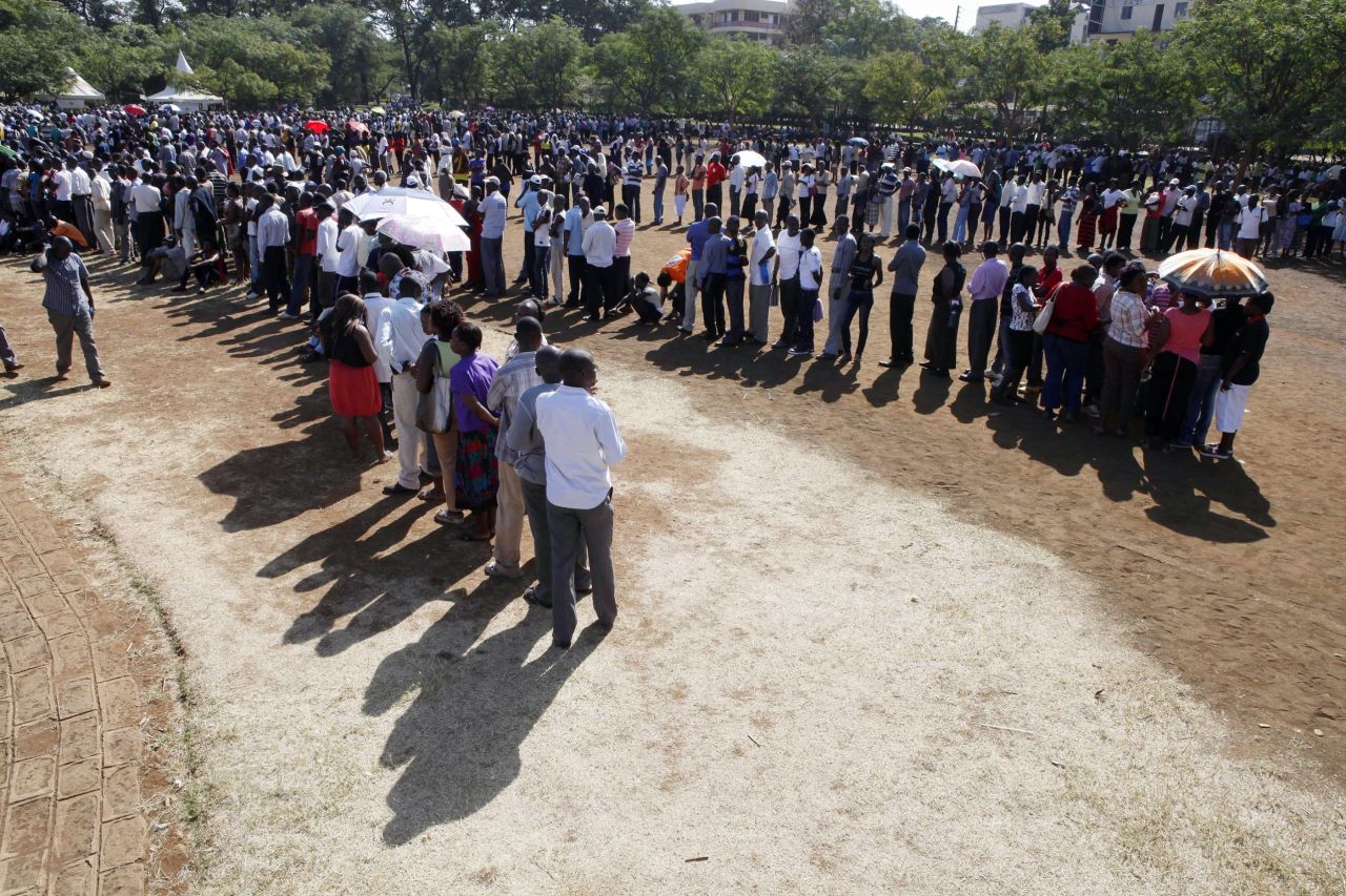 People stand in line to cast their vote at a polling stations in Kisumu, western Kenya on March 4, 2013 during the nationwide elections.
