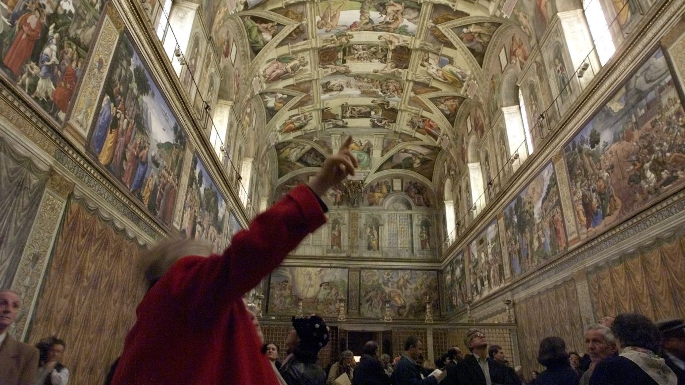 Journalists view the unveiling of the latest Sistine Chapel restoration on December 10, 1999.