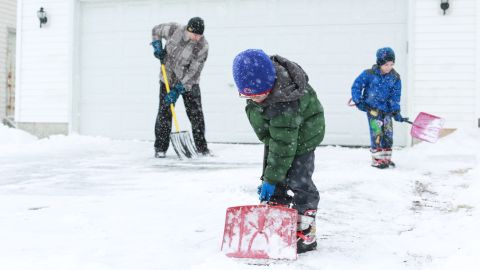 Left to right: Anthony Jordan and his 6-year-old twin sons Griffin and Landin shovel their driveway in Sycamore, Illinois, on March 5.