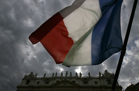  A French flag is waved in front of St. Peter's as white smoke billows from the chimney of the Sistine Chapel to announce the election of a new pope after a conclave lasting little more than 24 hours, on April 19, 2005.