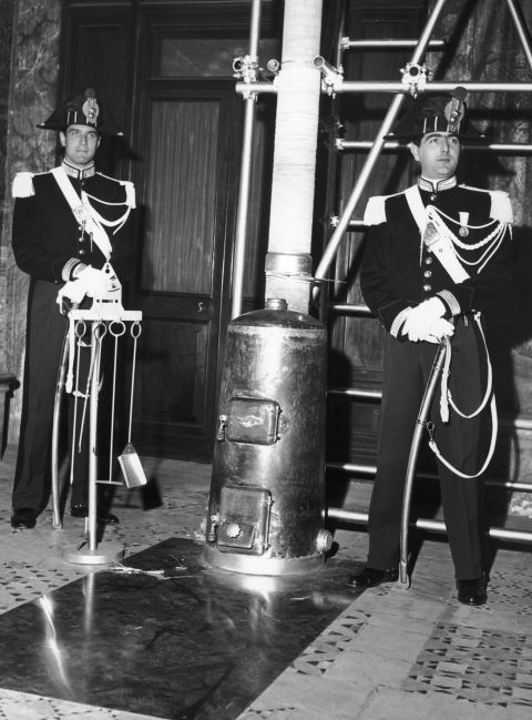 Two Vatican guards stand by the stove in which Catholic cardinals will burn their voting slips after electing a new Pope, Vatican City, 24 October 1958. 