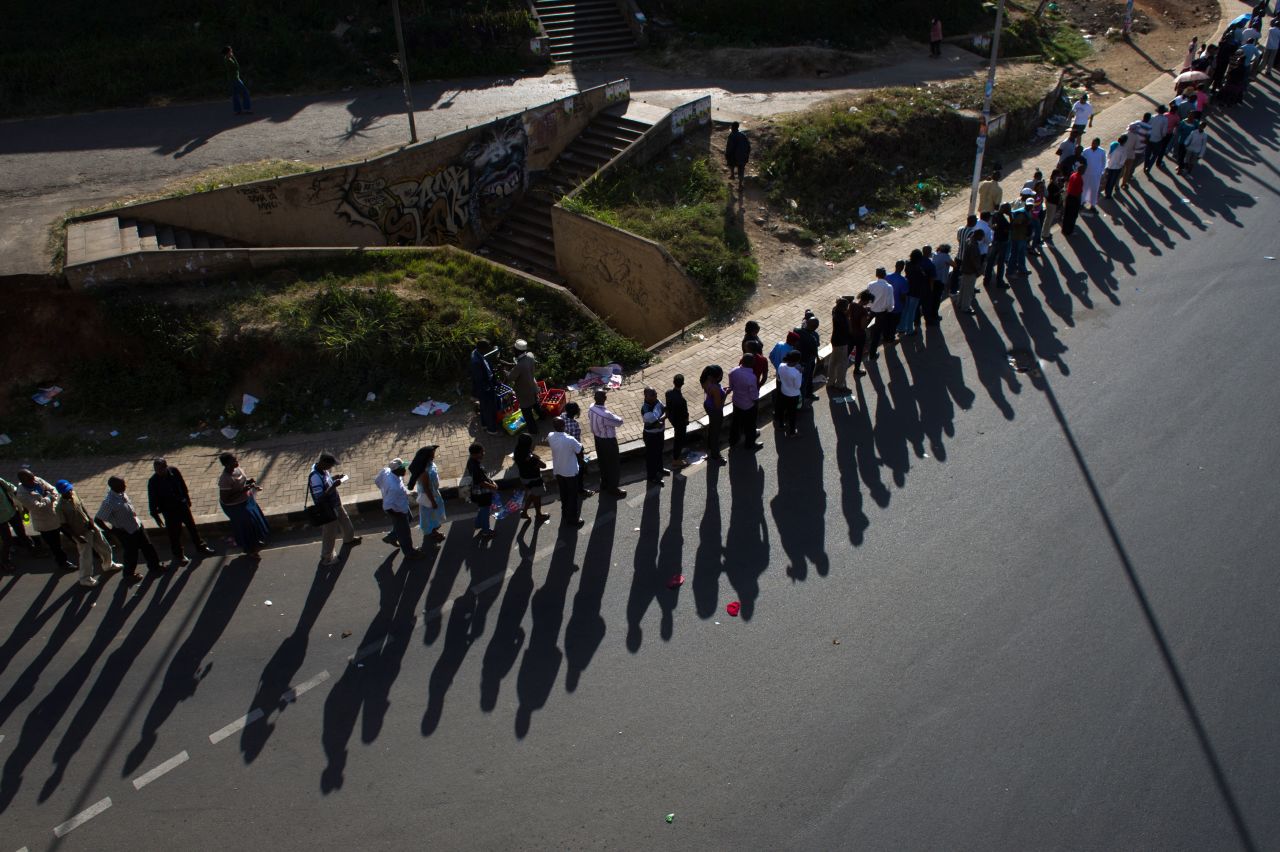 Shadows of a long queue of voters is cast upon the road, just before voting is due to close, in downtown Nairobi, the Kenyan capital, on March 4, 2013 as Kenyans vote in general elections.