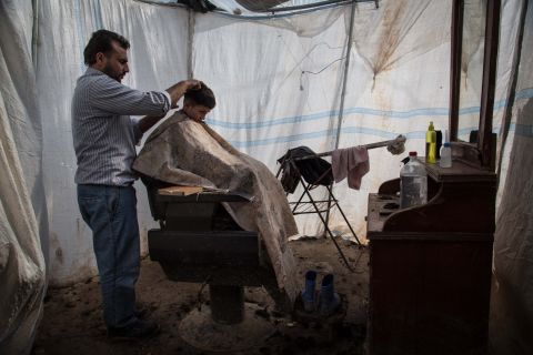 A child gets a haircut at a makeshift barbershop at the Azaz refugee camp in February 2013.
