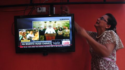 A Venezuelan woman adjusts the television while watching the news of Chavez's death on March 5 inside a Venezuelan restaurant in Panama City, Panama.