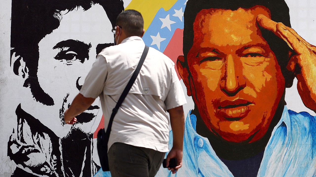 A man walks past a mural in Caracas portraying the South American liberator Simon Bolivar, the Venezuelan flag and Chavez on March 5.