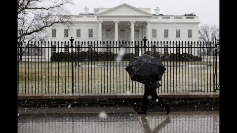 A man walks in front of the White House as snow and rain hit the Washington area on March 6.