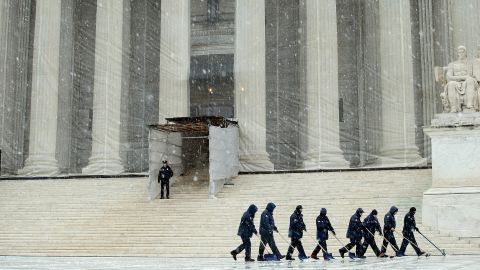 Workers use shovels and brooms to remove a heavy mixture of snow and ice from the west front of the U.S. Supreme Court on March 6.