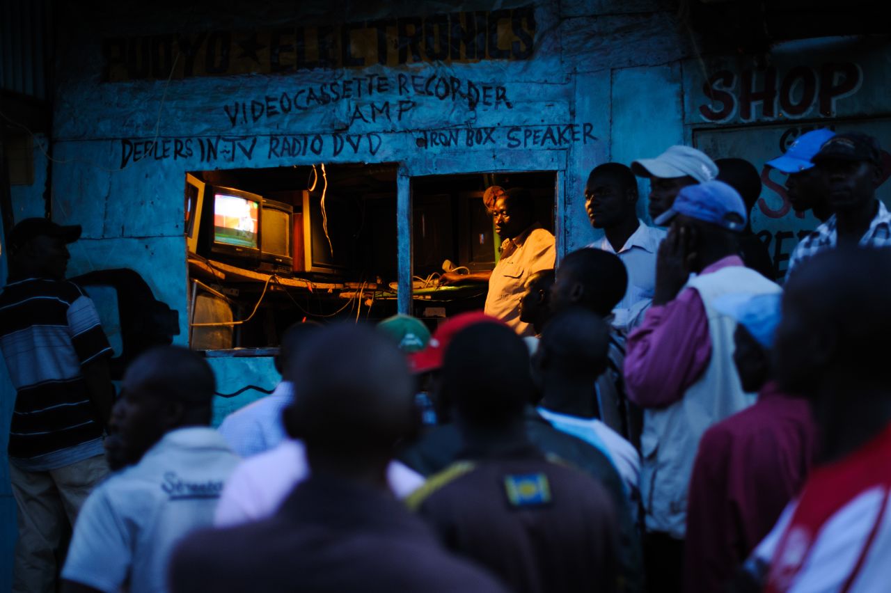 Men watch the incoming provisional election results on a television outside a shop in the Kibera slum of Nairobi, Kenya's capital, March 5, 2013.