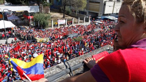A woman watches as Chavez's casket is driven through the streets of Caracas on March 6.