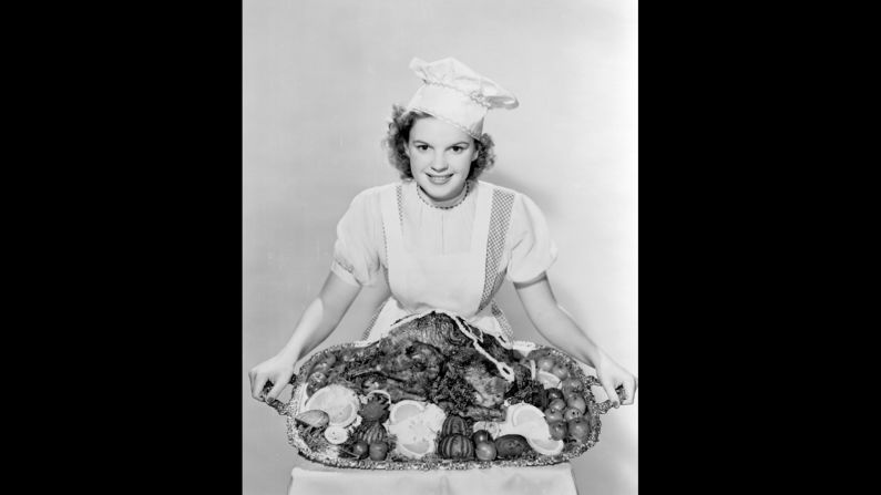 Judy Garland, dressed as Dorothy, poses with a turkey to promote the movie during Thanksgiving.