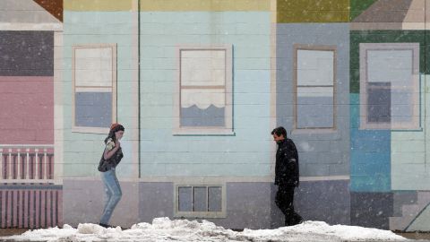A pedestrian walks past a mural at the beginning of a winter storm in Somerville, Massachusetts, on Thursday, March 7.