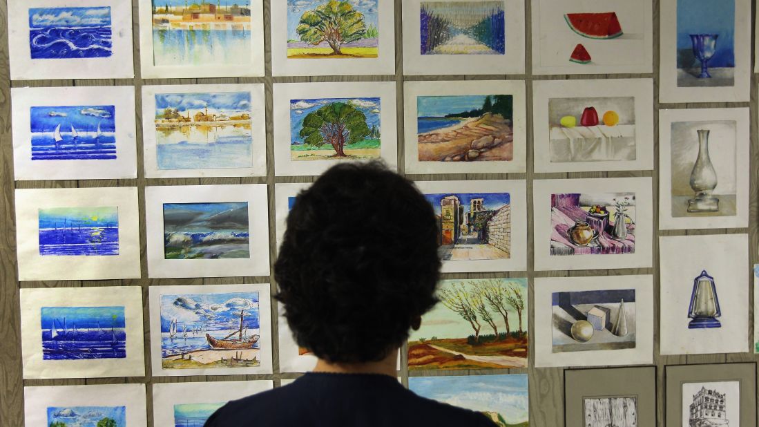 A camp librarian views artwork painted by detainees in September 2010. 