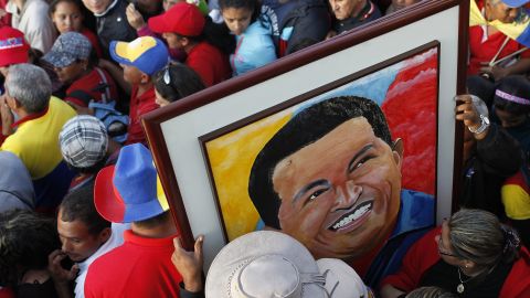 Supporters of Chavez hold a portrait of him as they wait for a chance to view his body at the military academy in Caracas on March 8.