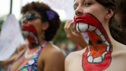 Women with their upper bodies painted pose as they take part in a protest against violence against women during the celebration of the International Women's Day on March 8, 2013, in Sao Paulo, Brazil. AFP PHOTO/YASUYOSHI CHIBA        (Photo credit should read YASUYOSHI CHIBA/AFP/Getty Images)