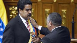 Diosdado Cabello (right) puts the presidential sash on Venezuelan Vice President Nicolas Maduro after he was sworn in as President in Charge, in Caracas.