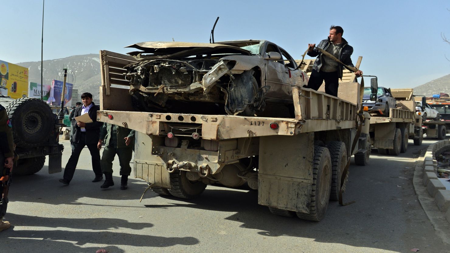 Afghanistan National Army soldiers remove a destroyed car at the site of a suicide attack next to the Defense Ministry in Kabul.