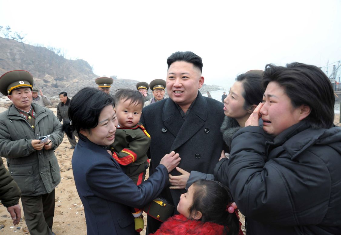 Kim is greeted by a soldier's family as he inspects the Jangjae Islet Defense Detachment in March 2013.