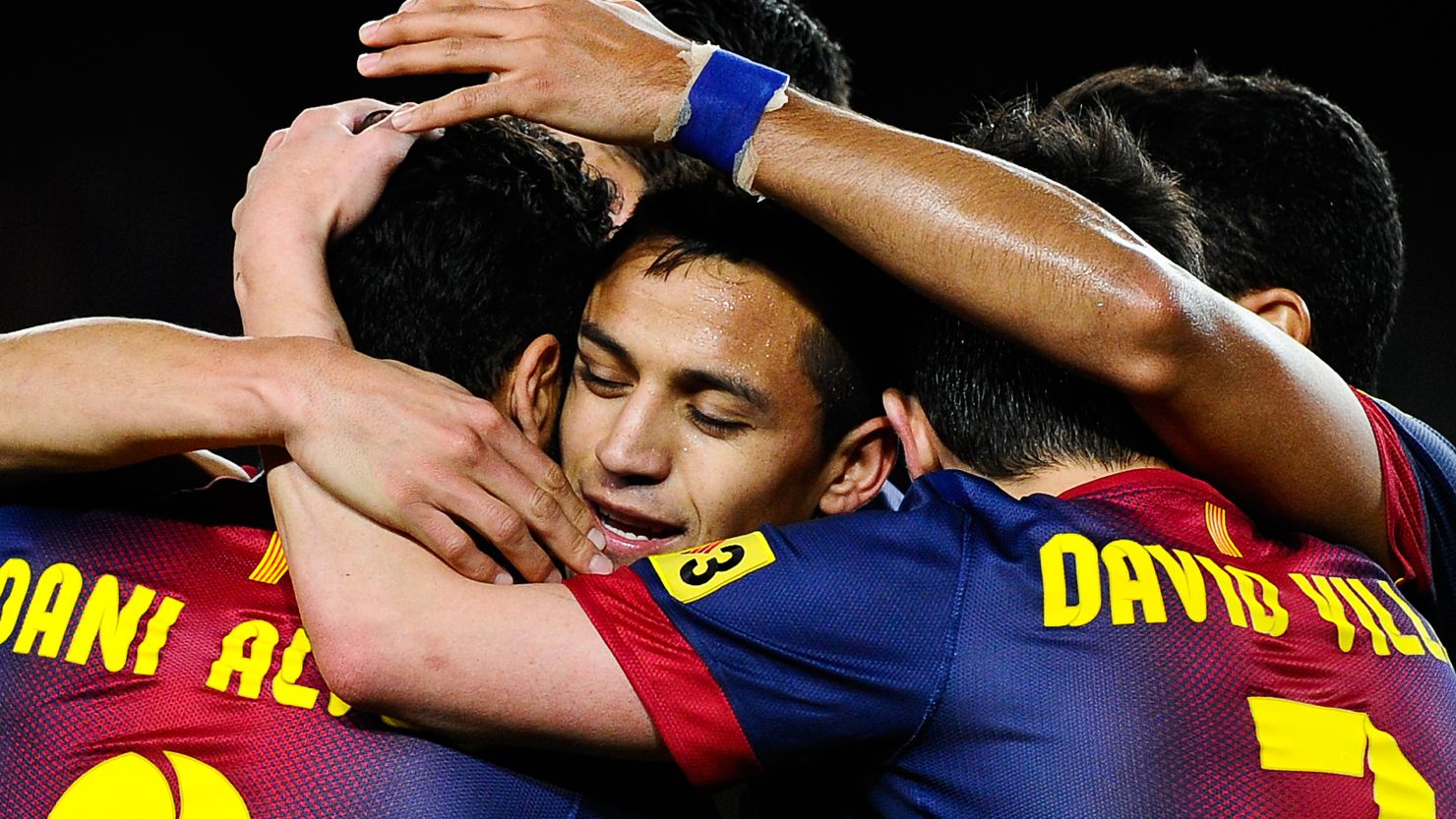 Alexis Sanchez is swamped by his teammates after scoring the opening goal against Deportivo La Coruna on Saturday. 