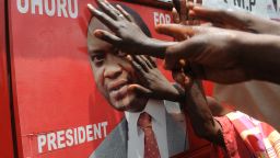 Supporters of Uhuru Kenyatta touch his picture on an election poster as they celebrate his victory.