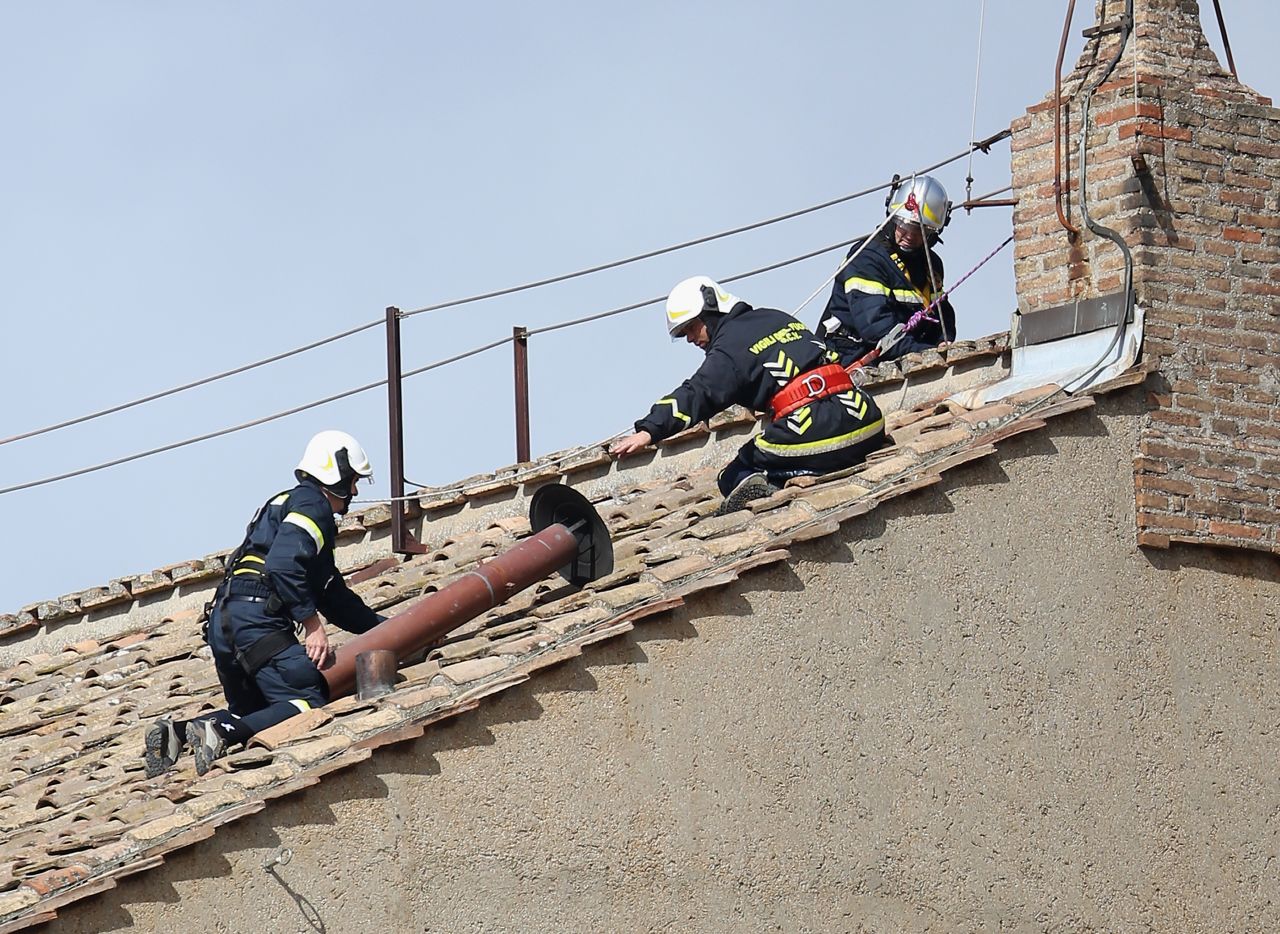 Members of the Vatican Fire Brigade install the chimney on top of the Sistine Chapel on March 9.