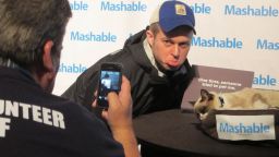 A man does his best grumpy face while posing for photos with Grumpy Cat, the famous Internet feline, at the South by Southwest festival.