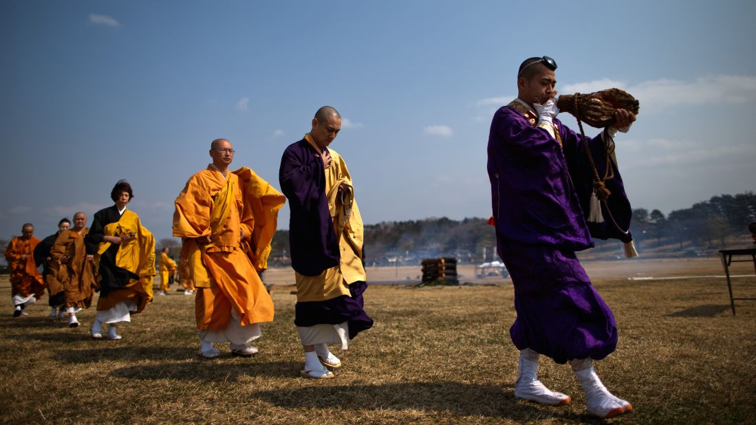 Japanese Buddhist monks chant and pay their respects to the victims on Sunday in Minamisoma.