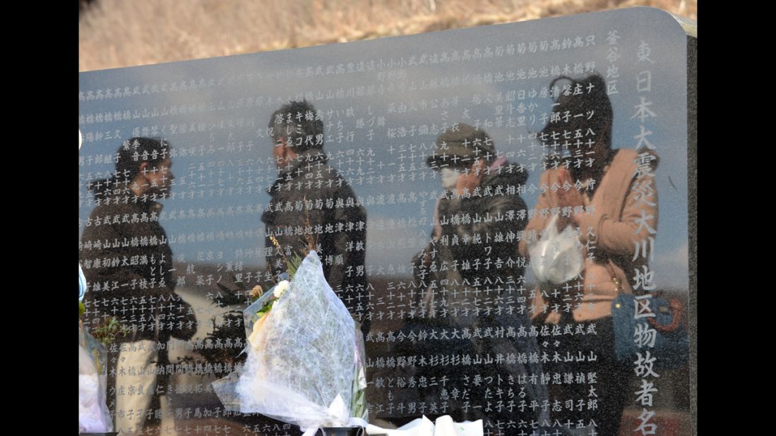People visit a memorial altar at the Okawa elementary school where at least 70 students died in the 2011 tsunami, in Ishinomaki, Japan, on Monday.