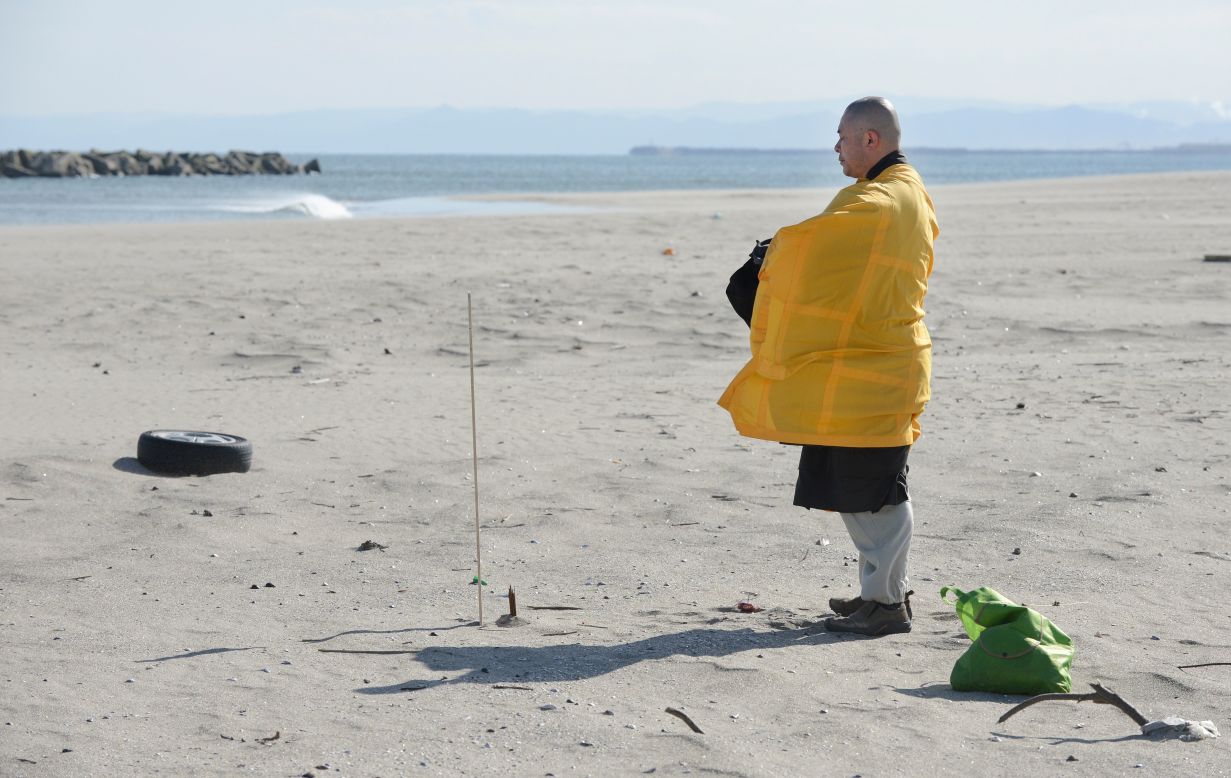 A Buddhist monk prays for tsunami victims at Arahama district in Sendai, Japan, on Monday.