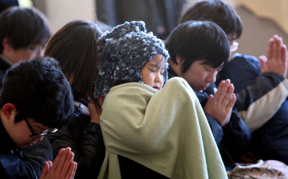 Children pray during a memorial ceremony to mark the second anniversary of the disaster in Kamaishi, Japan, on Monday.