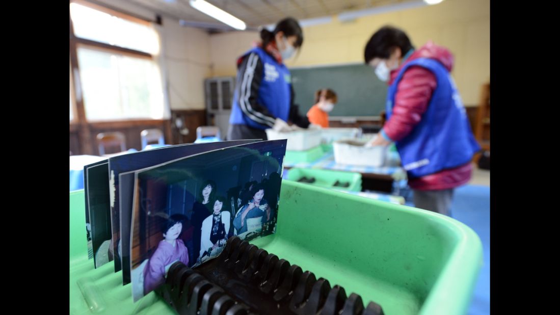 Volunteers clean pictures found in debris from the earthquake and tsunami disasters at the Tsukidate elementary school in Kesennuma, Japan, on Sunday, March 10.
