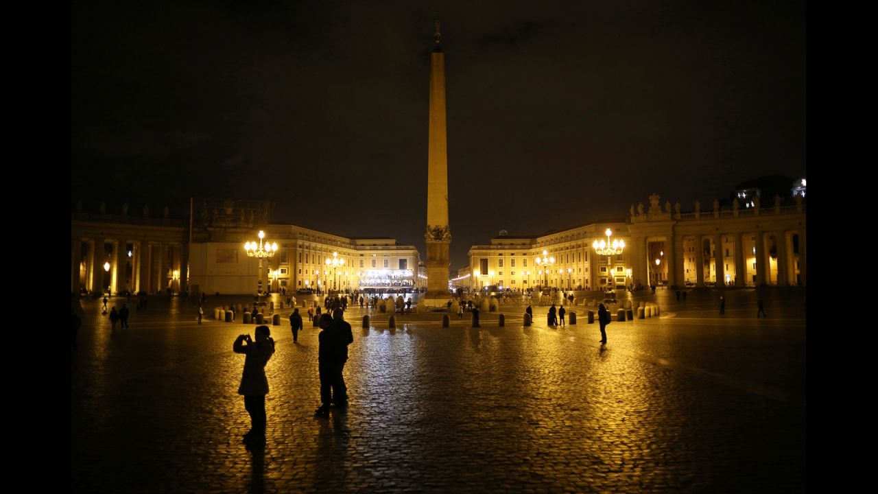 A few pilgrims are present in St. Peter's Square as night falls on Monday, March 11. 