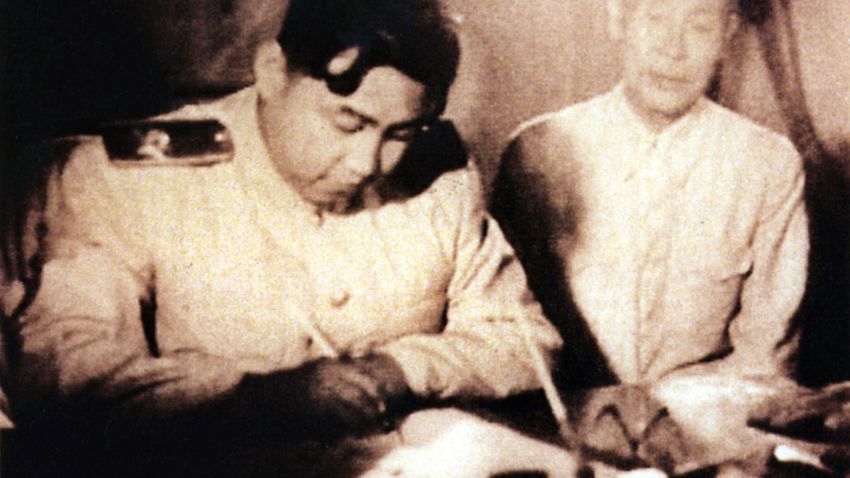 This undated photo shows North Korean leader Kim Il Sung (L) as he signs a document in Seoul, Korea.