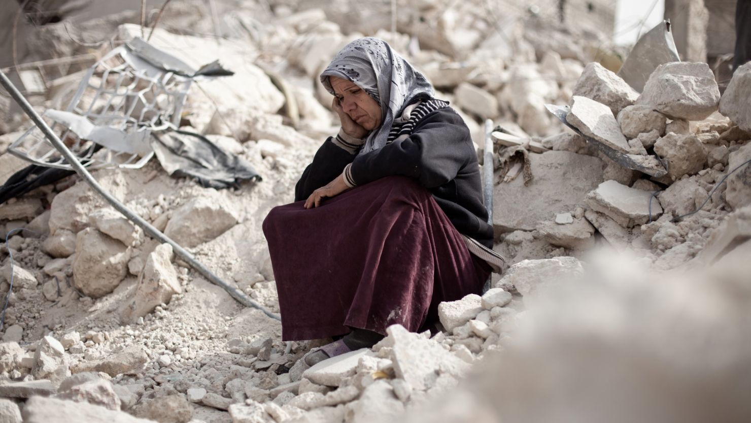 Syrian Zakia Abdullah sits on the rubble of her house in the Tariq al-Bab district of Aleppo, Syria, on February 23, 2013.