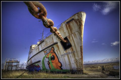 The first paintings to appear were of orange and blue pirates on the ship's bow, created by Latvian artist <a href="http://thekiwie.com/" target="_blank" target="_blank">KIWIE</a>. Each pirate is nine meters tall and includes the dates the ship was built (1956) and docked in Llanerch-y-Mor (1979).
