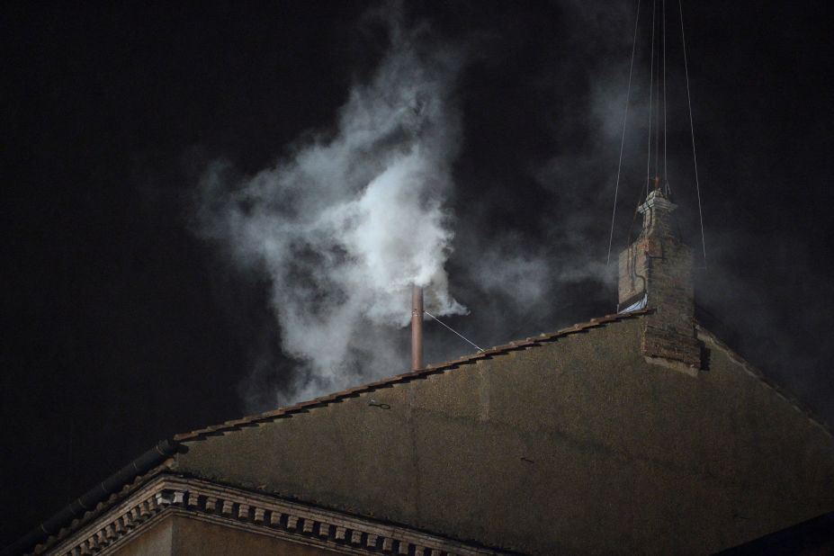 White smoke rises from the chimney on the roof of the Sistine Chapel.