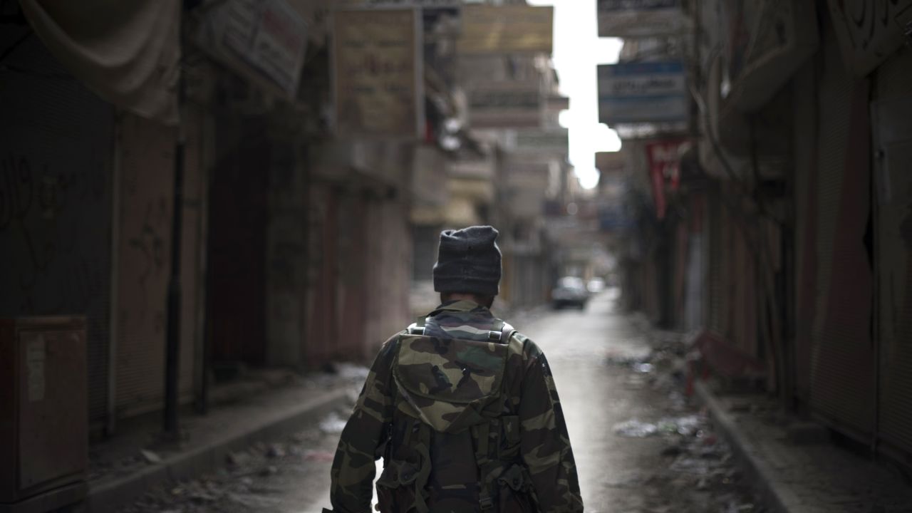 Rebel fighter walks through the ravaged Sit al-Ruba shopping street in the city of Deir Ezzor, Syria, on February 16, 2013.