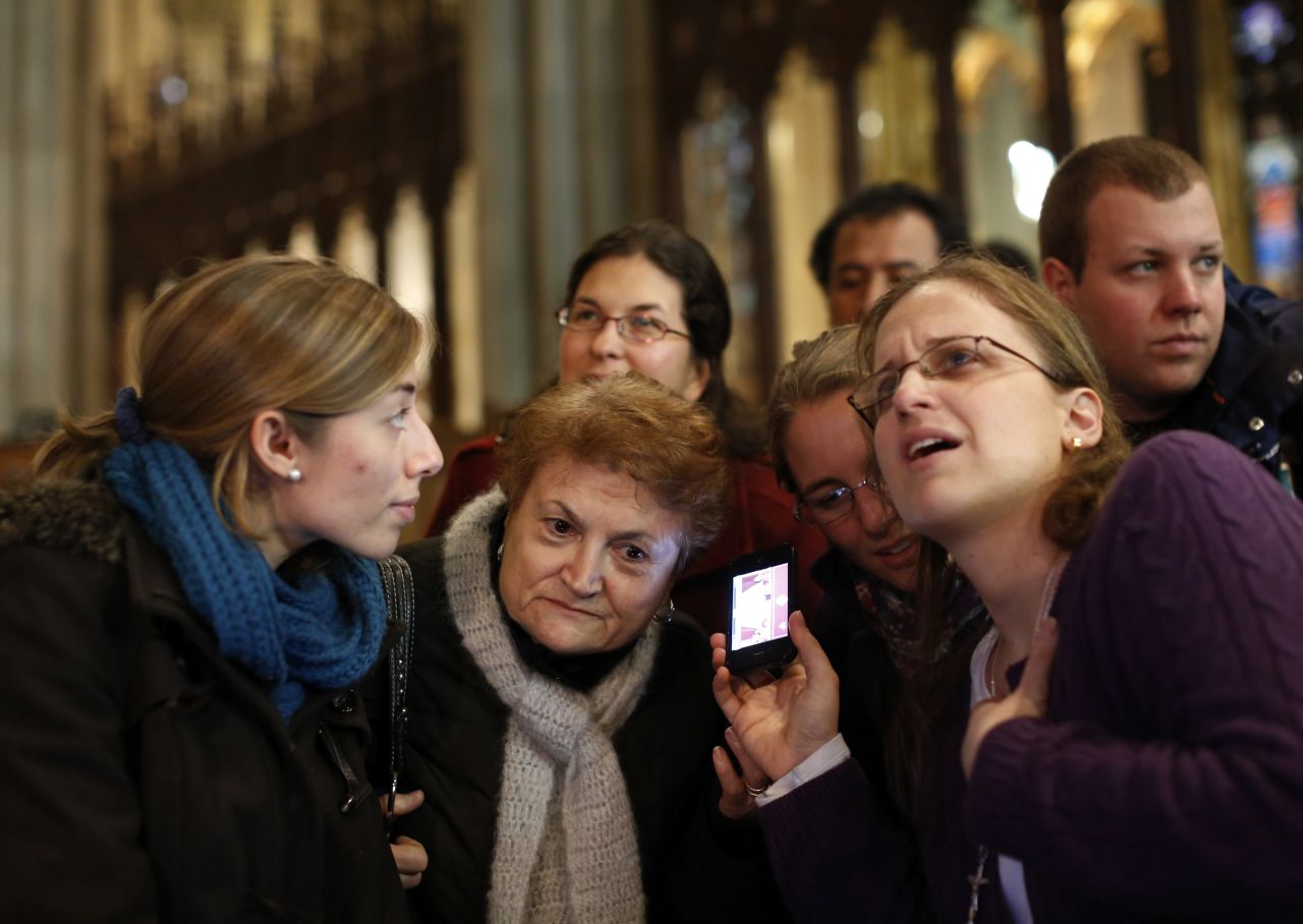 Florencia Silva, right, of Trumbull, Connecticut, and Valentina Bruner of Peru tune in to a webcast of newly elected Pope Francis at St. Patrick's Cathedral in New York.