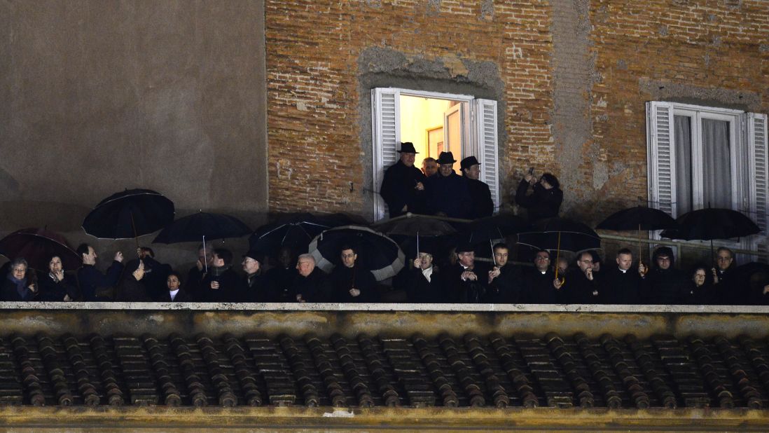 People stand on a balcony at St. Peter's Square as they wait for the identity of the new pope to be revealed.
