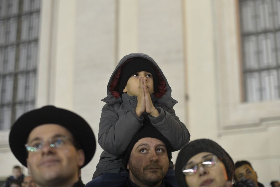 A boy sits on his father's shoulders in St. Peter's Square.