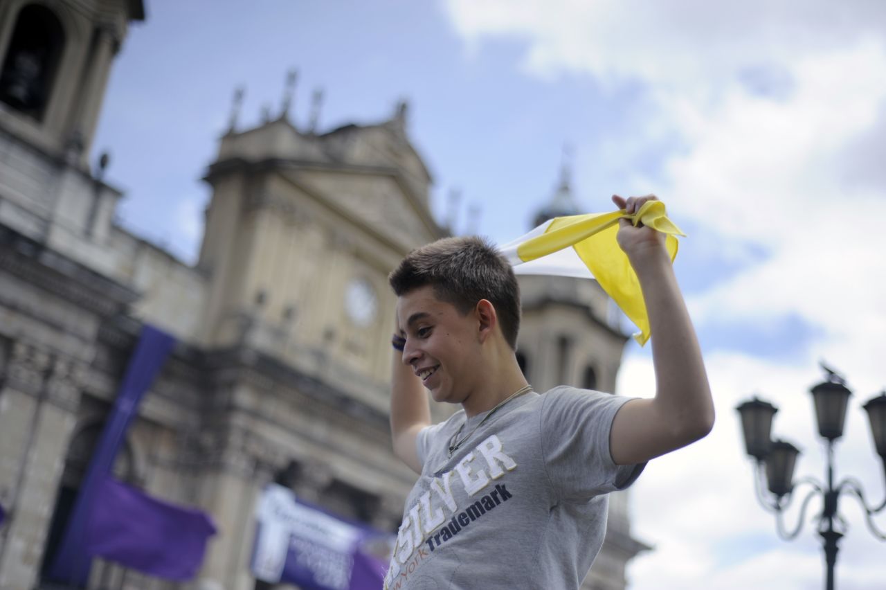 A young man waves a flag of the Vatican after the announcement of the election of Argentina's cardinal Jorge Bergoglio, as Pope Francis in Guatemala City.