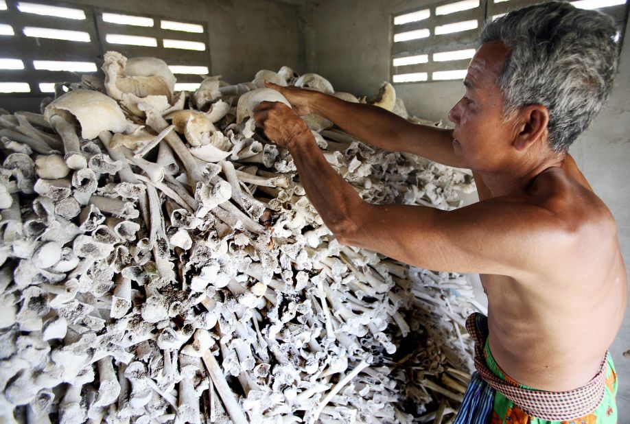 Cambodian Sao Phen prepares skulls and bones of victims of the Khmer Rouge inside a stupa in Kandal province in 2009. 