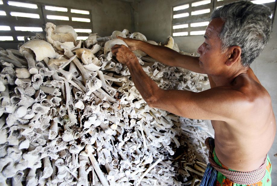 Cambodian Sao Phen prepares skulls and bones of victims of the Khmer Rouge inside a stupa in Kandal province in 2009.