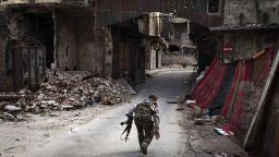 A Syrian rebel crosses a street while trying to dodge sniper fire in the old city of Aleppo in northern Syria on March 11, 2013. Syria warned on March 12 it is ready to fight 'for years' aga