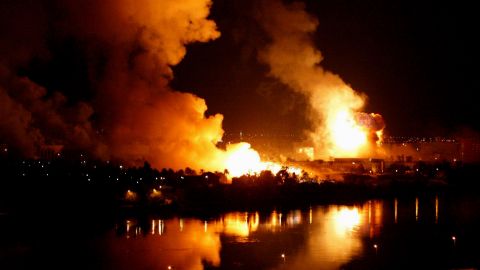 Smoke and flames rise from the riverside presidential palace compound in Baghdad after a massive airstrike on March 21, 2003.