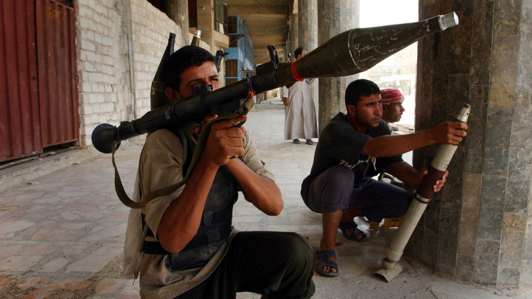 Shiite militia members prepare to fire during clashes with U.S. forces in Najaf on August 7, 2004. It was the third day of continuous fighting in the holy city.