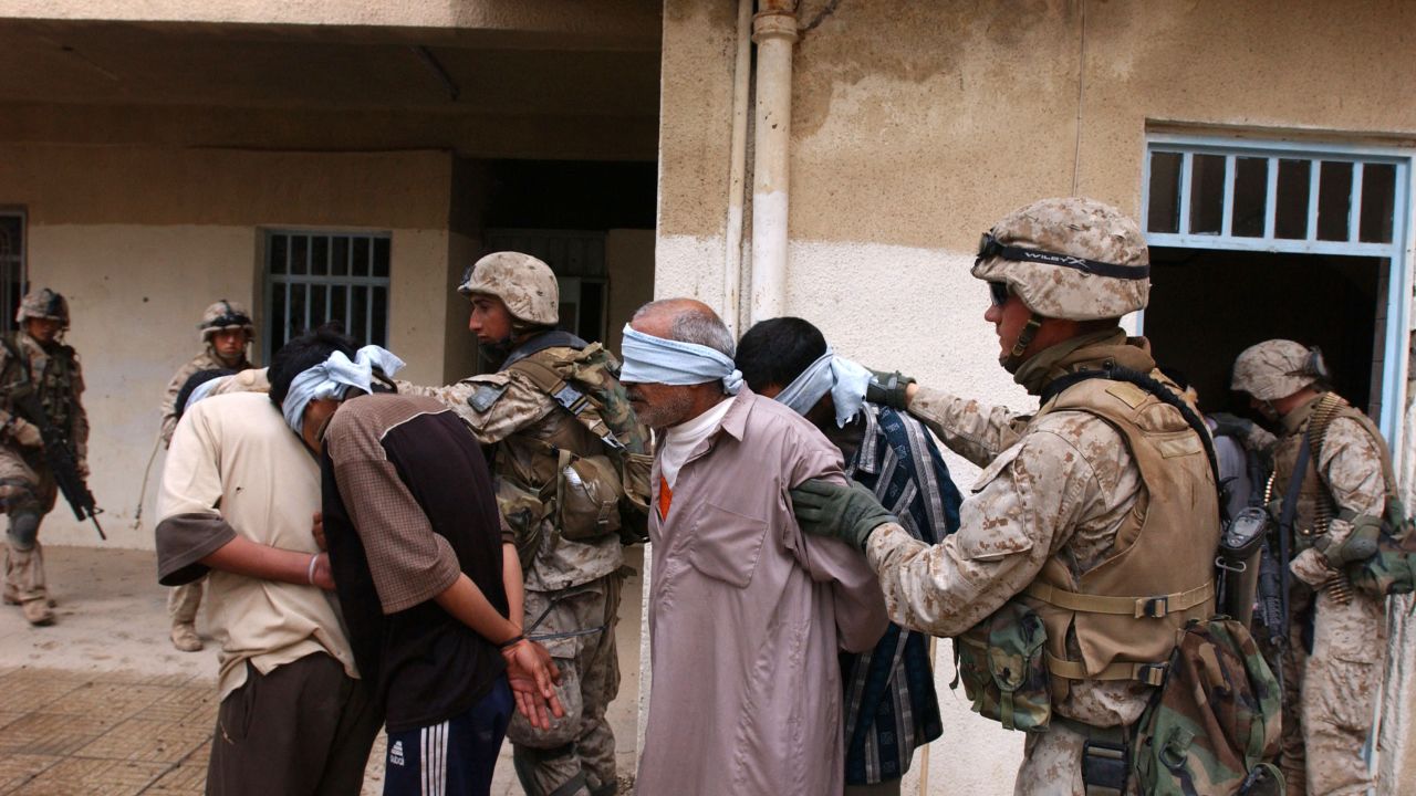 Iraqi men are arrested during a house raid in Fallujah on November 13, 2004.