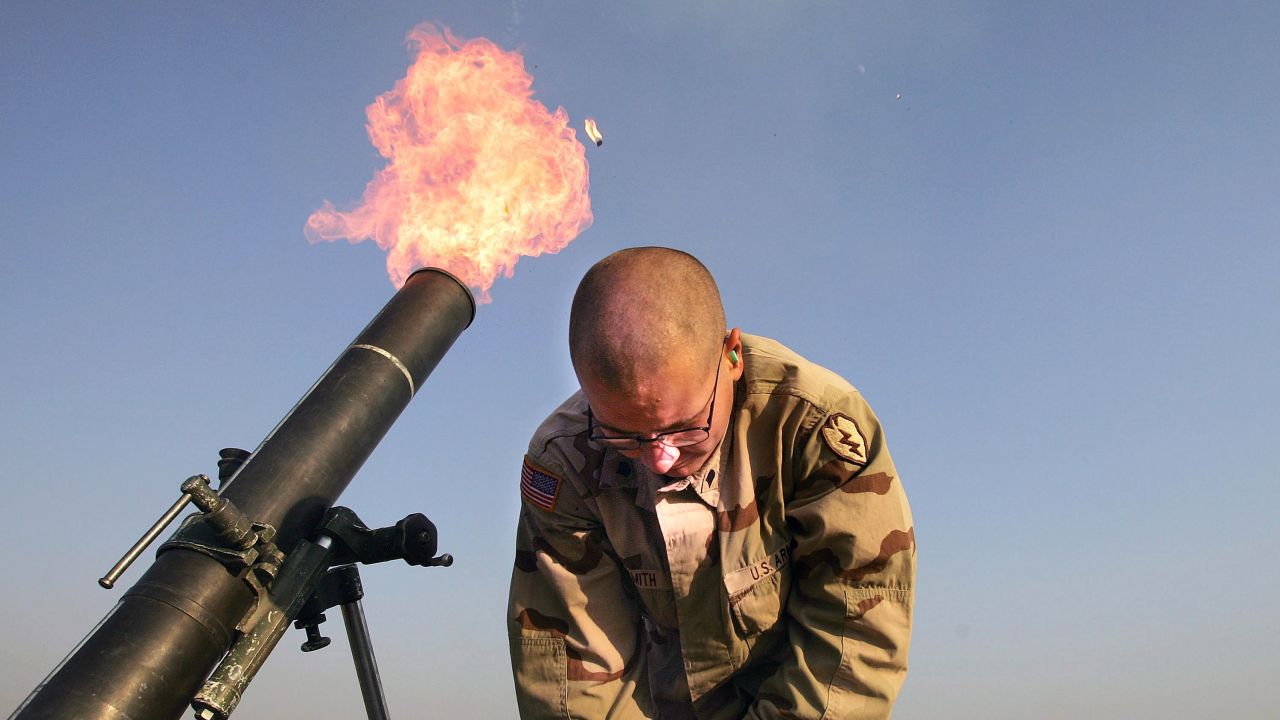 Spc. Franklin Smith pulls away as a mortar blast is fired from the edge of the U.S. airbase in Tal Afar on January 17, 2005. U.S. teams would frequently fire "harassment and interdiction" mortar fusillades toward suspected enemy positions.