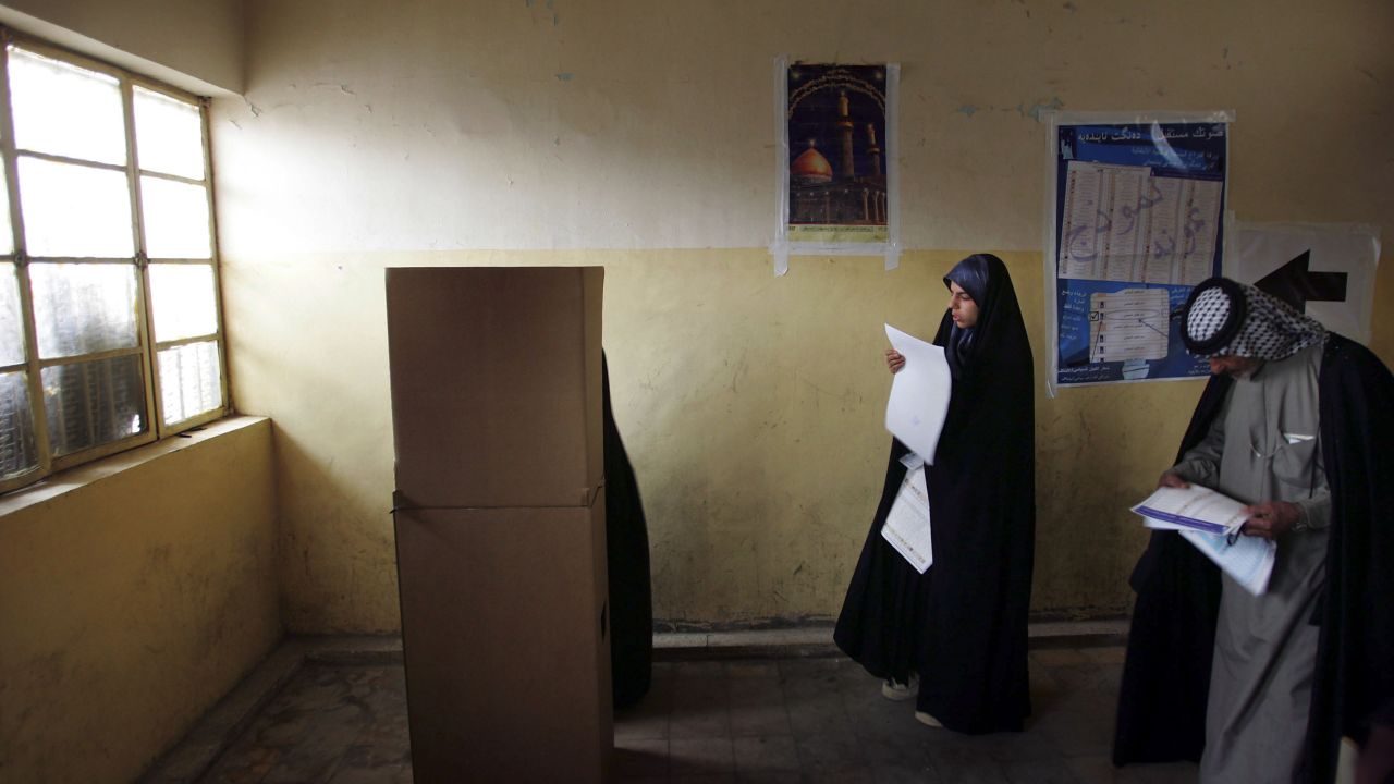 Iraqis look over their ballots on election day in the Sadr City neighborhood of Baghdad on January 30, 2005. It was the country's first multiparty election in half a century.