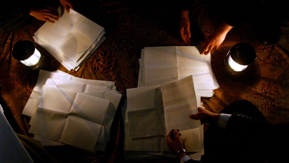 Election officials count ballot papers at night on January 30, 2005, in the Shiite holy city of Najaf. Despite threats, thousands of men and women cast their votes.
