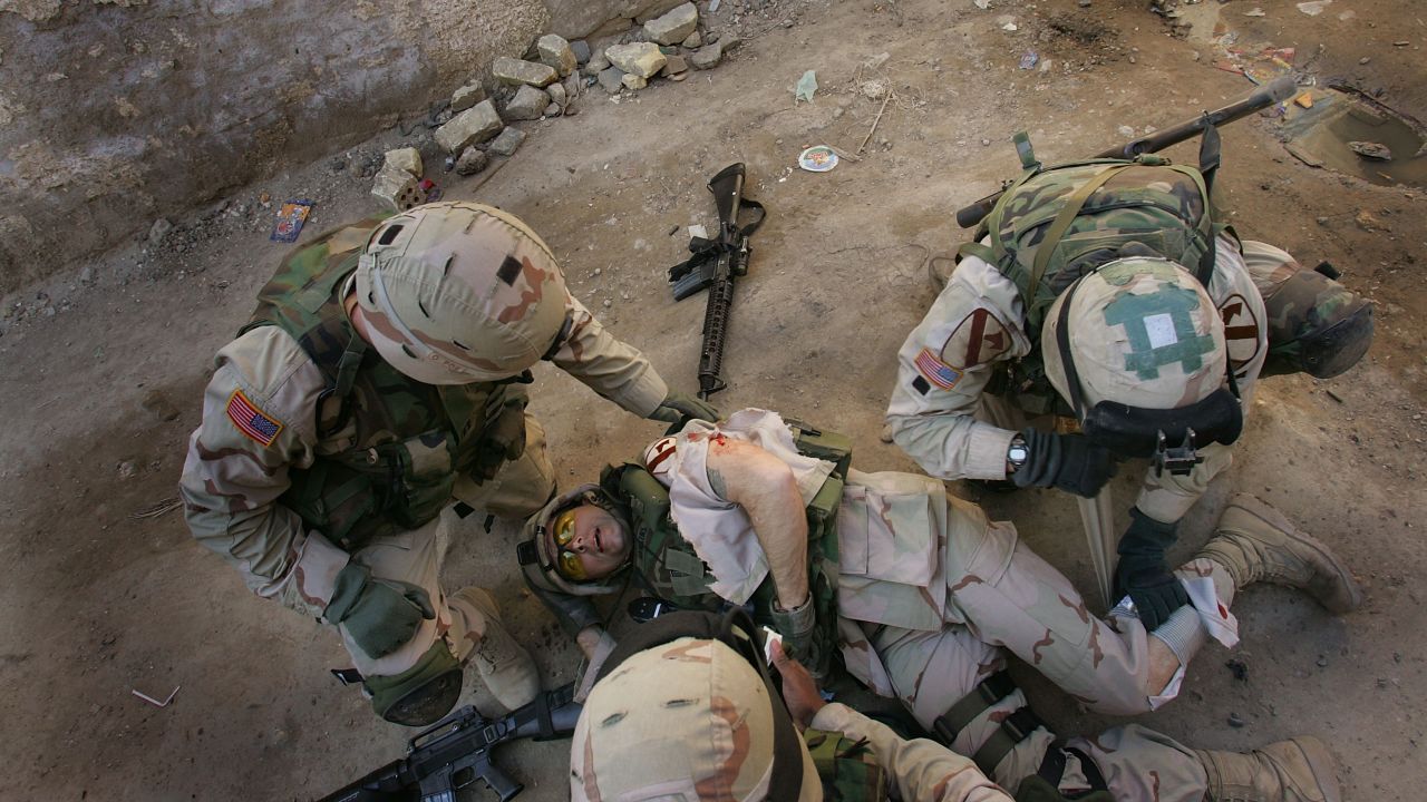Army Sgt. 1st Class Troy Hawkins is tended to after getting wounded during a firefight while on patrol with an Iraqi army unit in the Haifa Street neighborhood of Baghdad on February 16, 2005. Afterward, he continued to fight in the narrow streets.